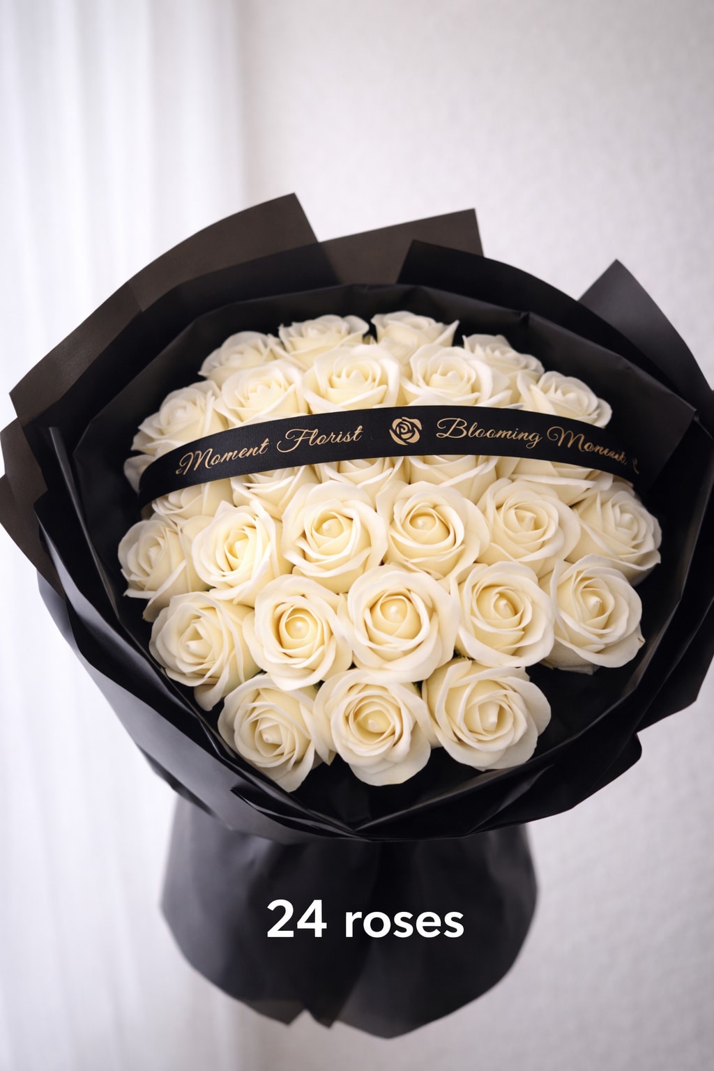 [SOAP FLOWER]Elegant ivory rose bouquet arrangement - A timeless expression of love and sophistication, this bouquet features 24 perfectly arranged ivory roses in full bloom. Each rose is carefully selected for its smooth petals and soft, creamy tone, creating a clean and luxurious look. Wrapped in signature matte black paper and finished with a satin ribbon, the contrast enhances the bouquet’s modern and elegant style.  Designed in a classic rounded shape, this arrangement offers a full and balanced appearance—perfect for anniversaries, romantic gestures, birthdays, or any moment that calls for understated beauty.  Flower Meaning: Ivory roses symbolize purity, sincerity, and everlasting love.