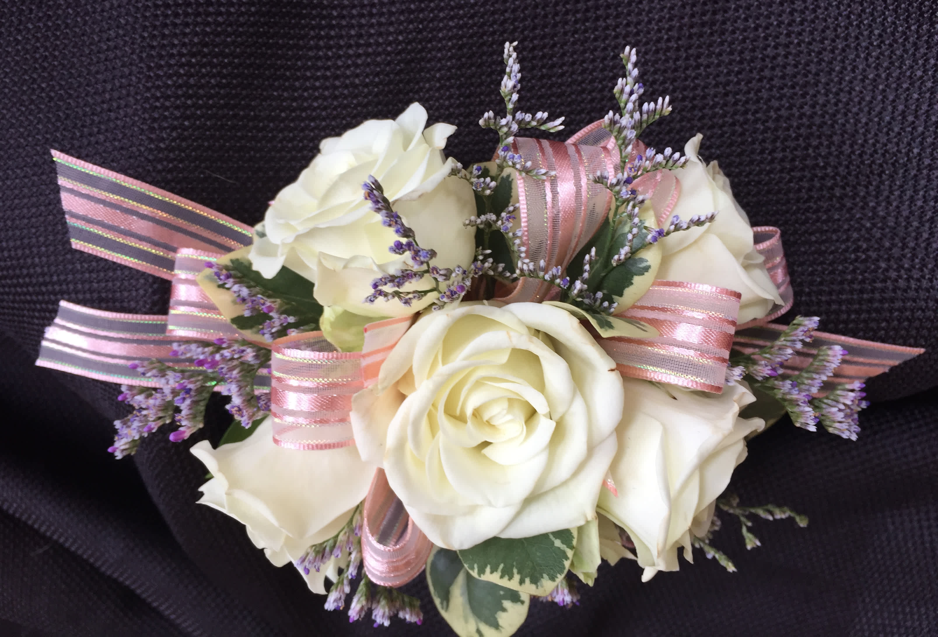 Corsage 5 rose standard - This corsage has 5 spray roses with greens and filler. We have all sorts of ribbon from lime green sparkle to animal print, just tell us in the special instructions what your looking for! You may also send us a picture of your dress or inspirations to our email address lvfloral@gmail.com just make sure to include your name and order number.   ALL corsage/boutonniere orders will be ready for PICK UP ONLY between 1pm-4pm the day of the event. 