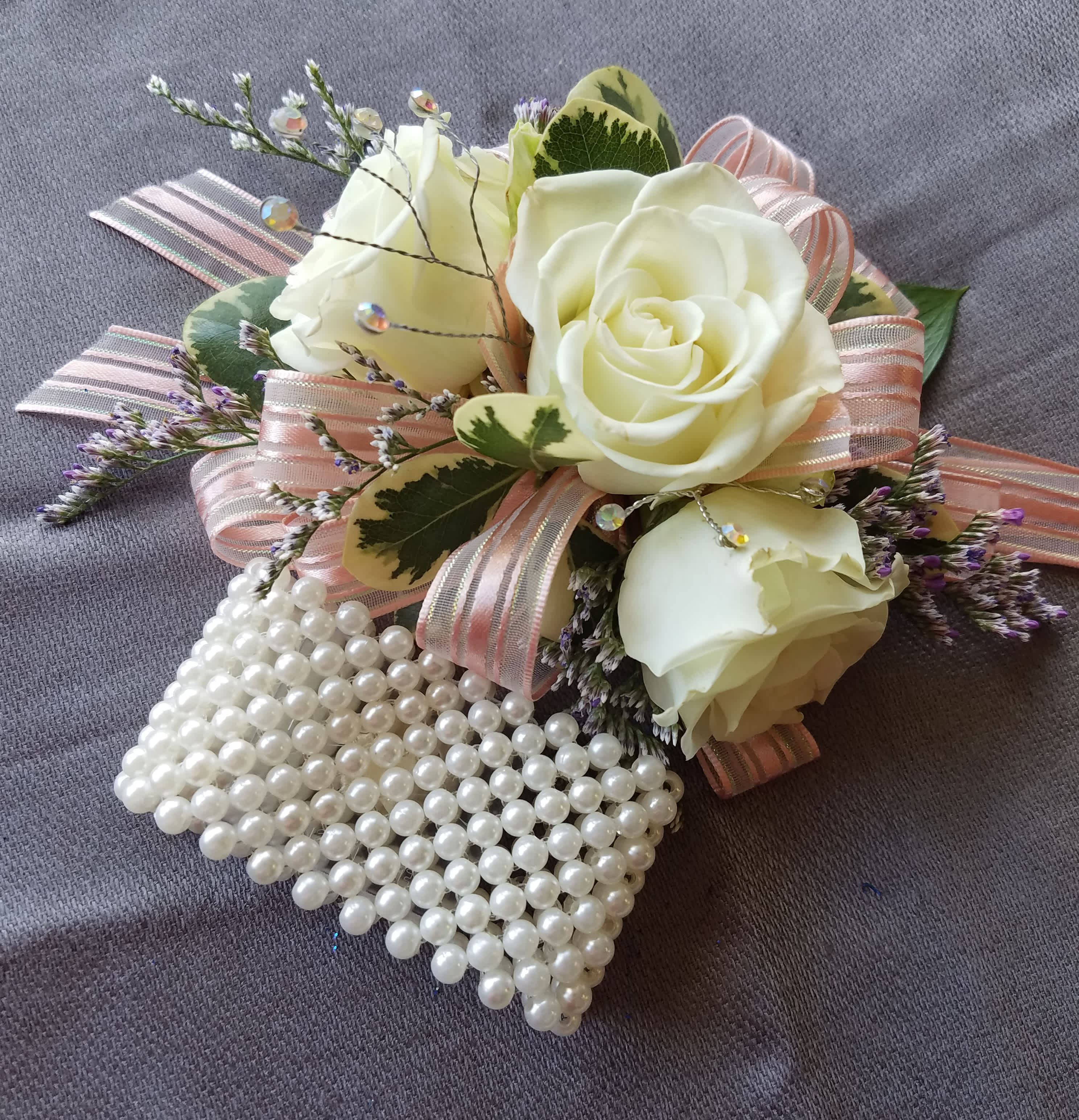 Corsage 3 Rose Premium  - This corsage has 3 spray roses of common colors with greens, filler, upgraded bling, and upgraded bracelet. We have all sorts of ribbon from lime green sparkle to animal print, just tell us in the special instructions what your looking for! You may also send us a picture of the dress or inspirations to our email address lvfloral@gmail.com just make sure to include your name and order number.    ALL corsage/boutonniere orders will be ready for PICK UP ONLY between 1pm-4pm the day of the event. 