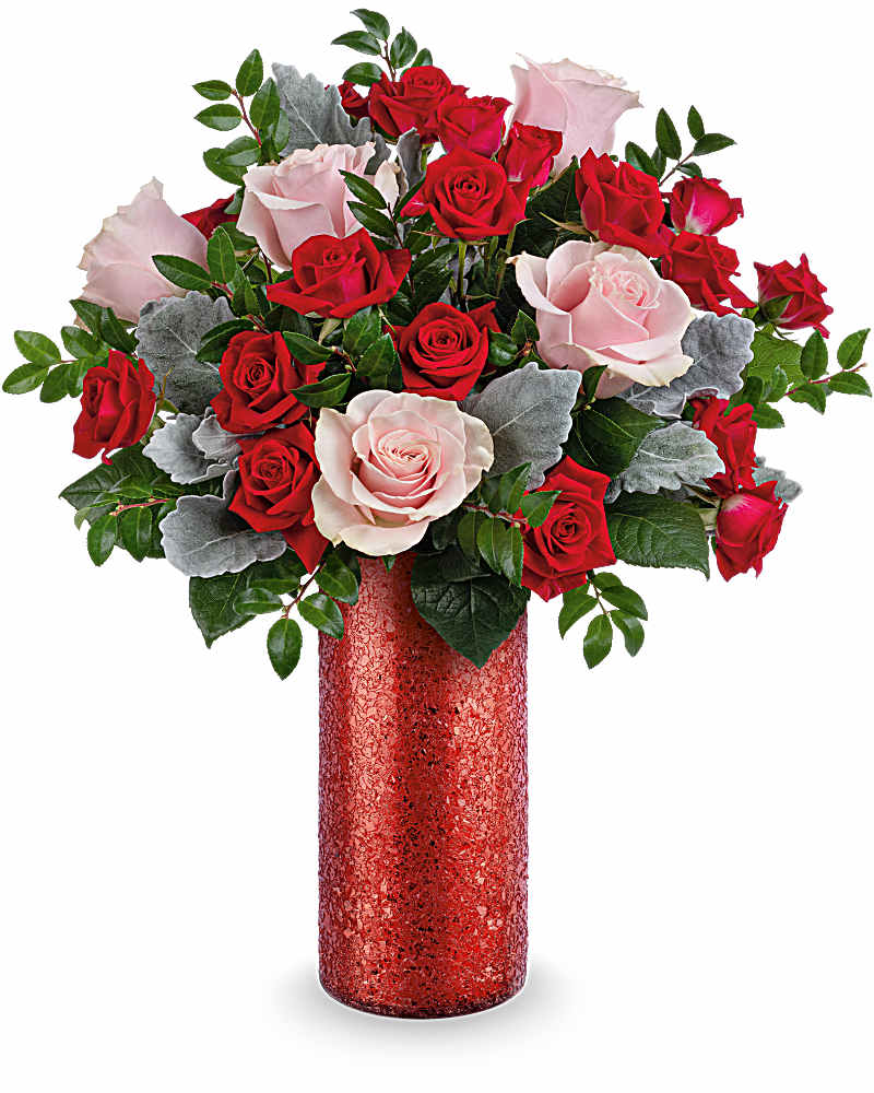 Tall arrangement of red and light pink roses in a glittery red cylinder vase