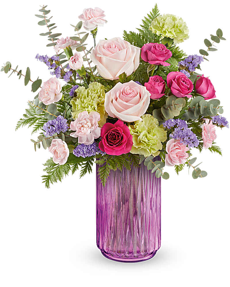 Mixed bouquet of pink roses, green carnations, and pastel blooms in a tall purple glass vase