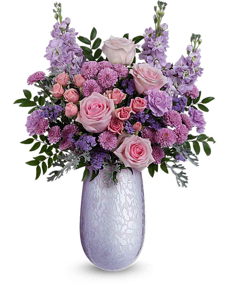 Tall lavender and pink flower arrangement with roses and mums in a pale purple glass vase