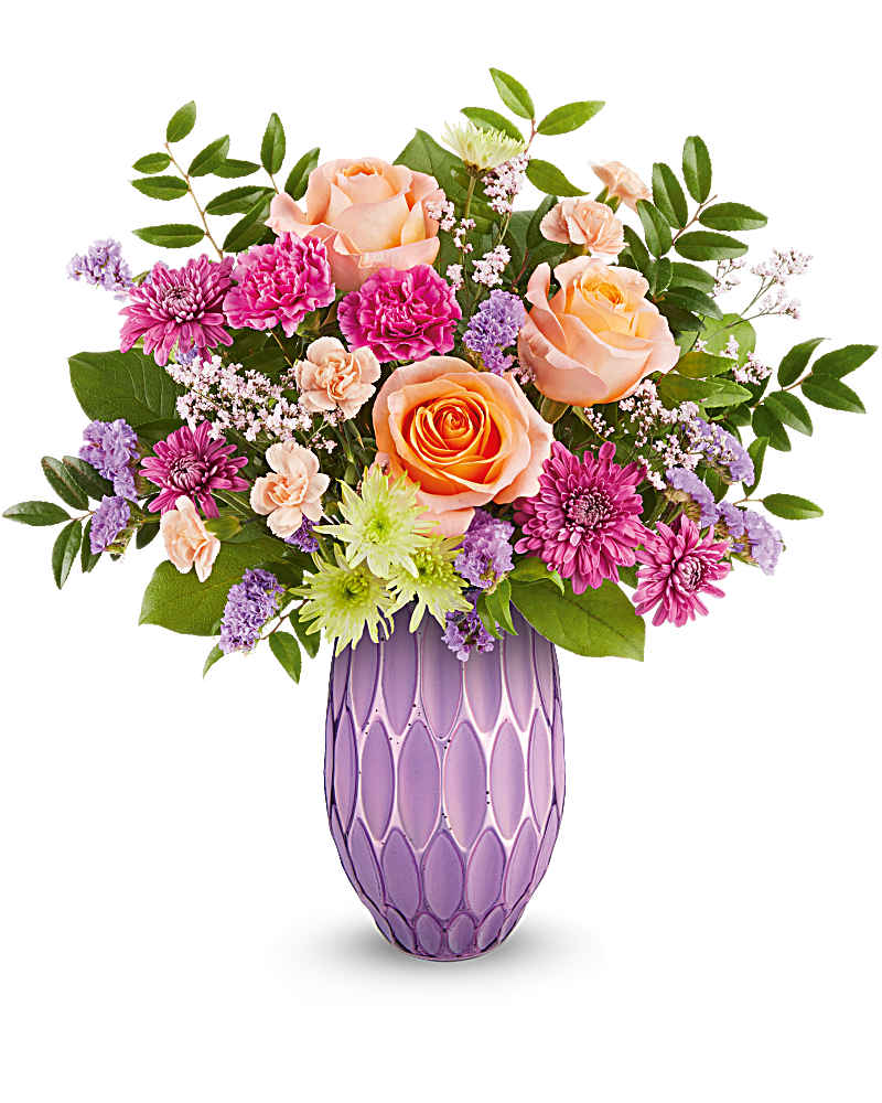 Arrangement of peach roses and mixed pink and purple flowers in a tall lavender vase