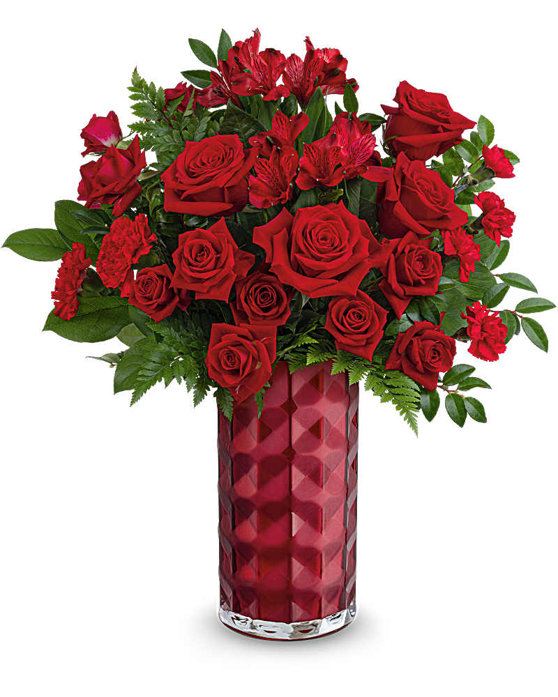Tall arrangement of red roses, carnations, and alstroemeria in a faceted red glass vase