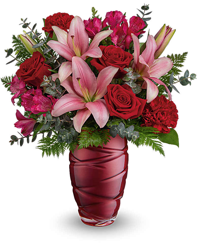 Arrangement of pink lilies, red roses, carnations, and alstroemeria in a deep red glass vase