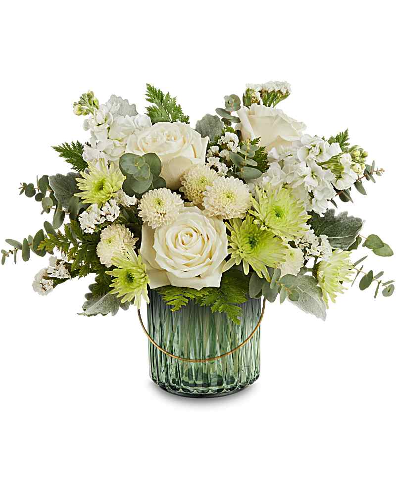 Low arrangement of white roses and mums with pale green accents in a ribbed green glass vase