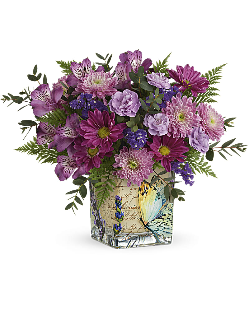 Purple and pink mixed bouquet in a square glass vase with a butterfly design