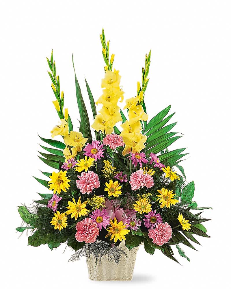 Tall fan-shaped arrangement with yellow gladiolus, pink carnations, and yellow daisies in a light container