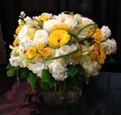 Yellow and white mixed flower arrangement in a glass vase