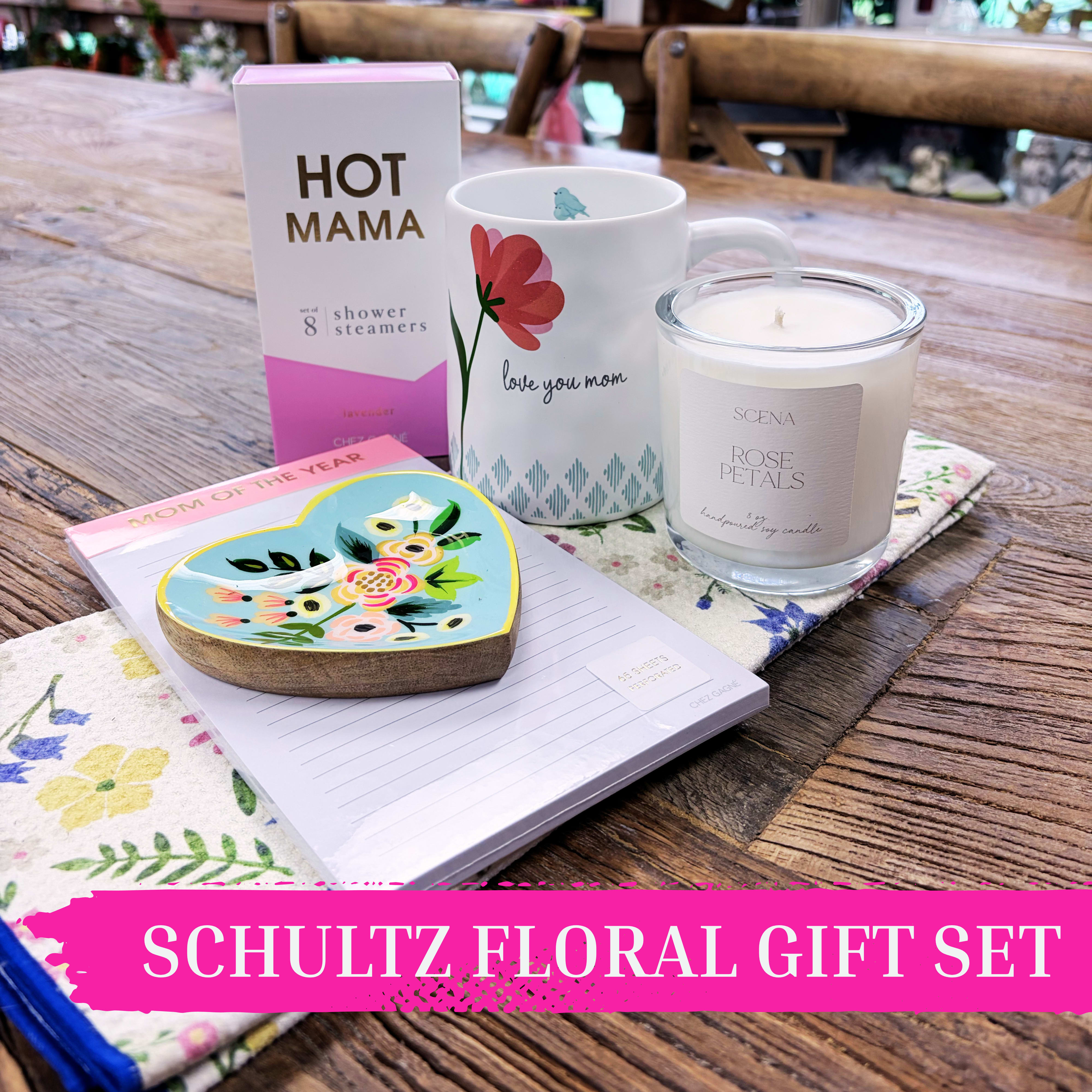 “Mom of the Year” Self-Care Gift Set | Mother’s Day Gift Set by Schultz Floral - Show Mom how much she’s appreciated with this thoughtfully curated self-care gift set. Combining sweet floral touches with cozy indulgences, it’s perfect for Mother’s Day, birthdays, or celebrating the everyday hero in your life.  This charming collection includes: – “Hot Mama” Lavender Shower Steamers (set of 8) for a calming at-home spa experience – Heart-shaped floral trinket dish, perfect for jewelry or keepsakes – Floral-themed tea towel to brighten her kitchen – Hand-poured Rose Petal candle (8oz Soy Candle), a Schultz Floral best-seller of 2026 – “Love You Mom” ceramic mug for coffee, tea, or hot cocoa – Mom of the Year lined notepad for notes, lists, or daily reminders of how loved she is  Beautifully packaged and ready for local pickup or Valparaiso delivery, this gift set makes showing love effortless and unforgettable.