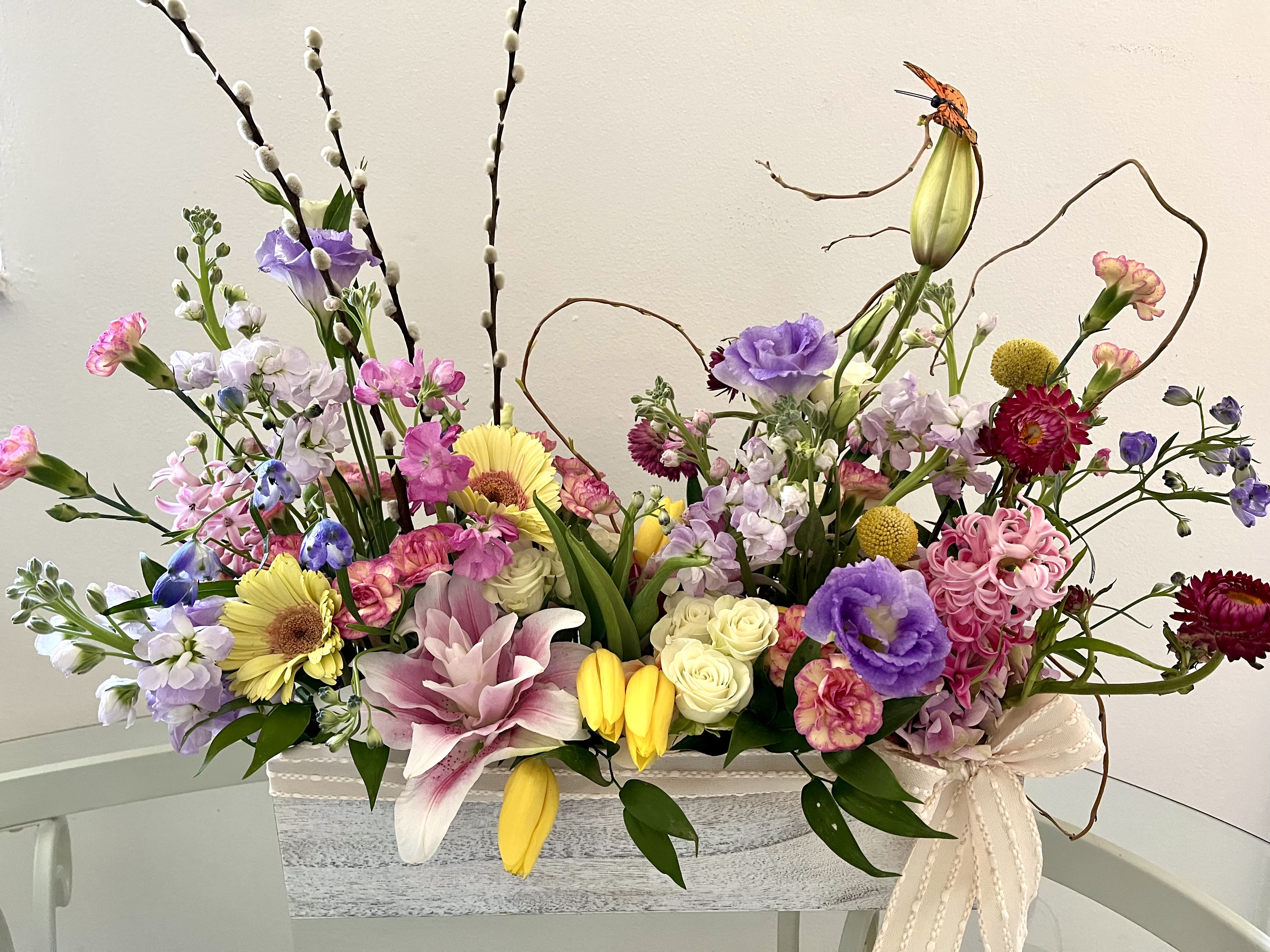 Happy Spring - Celebrate the season with a cheerful mix of fresh, seasonal blooms. The Happy Spring arrangement features a vibrant assortment of spring flowers  in a variety of colors and textures, bringing the joy and renewal of spring right to your space. Perfect for brightening  any room or sending a little sunshine to someone special. 