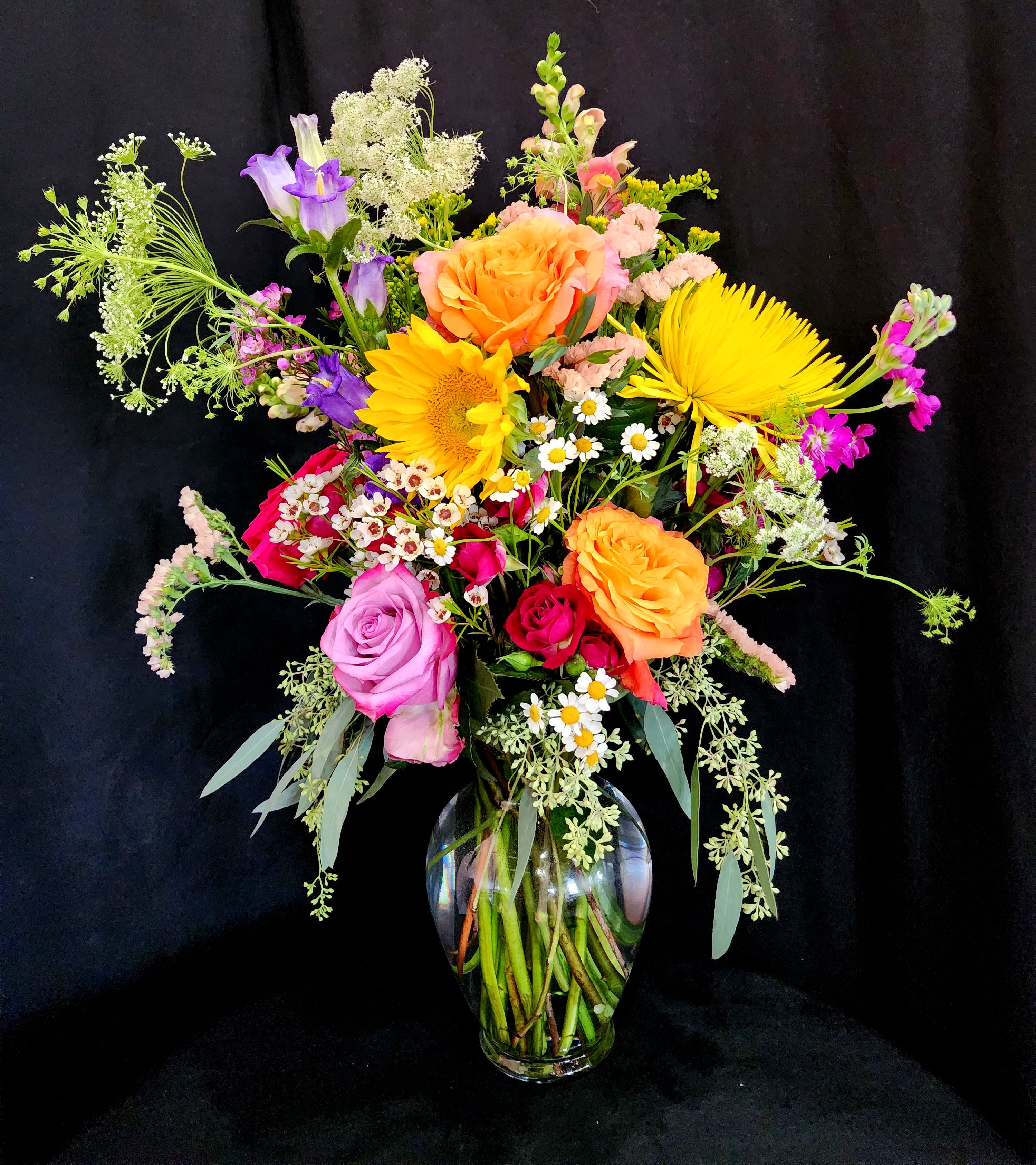 The Bad Ass  - This arrangement represents the signature style of Buds Blooms &amp; Bad Asses, displaying the variety of unique flowers with a natural garden look. Perfect for a gift to someone who is a certified BAD ASS!   dimensions are as follows:  23" Height x 17" Length x 10" Width in an 8" glass vase.  