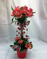 Sweetheart Bloom Tower - Celebrate love in full bloom with the Sweetheart Bloom Tower, a stunning Valentine’s Day arrangement designed to steal hearts. Featuring vibrant pink and coral blossoms artfully arranged in a unique, vertical display, this floral tower is adorned with a charming heart-patterned ribbon that adds a festive and romantic touch.  Nestled in a sleek red pot, it’s the perfect centerpiece for a romantic dinner, a thoughtful gift for someone special, or a cheerful decoration to brighten up any space. Its fresh, lively blooms and creative design make it a standout Valentine’s surprise that goes beyond traditional bouquets.  Why It’s Perfect for Valentine’s Day?  Eye-Catching Design – A beautiful vertical arrangement that’s unique and elegant. ️ Festive Heart Ribbon – Adds a playful, romantic vibe to the display.  Ready-to-Gift – Comes in a stylish red pot, perfect for display with no extra fuss.  Long-Lasting Blooms – Enjoy fresh, vibrant flowers that last beyond Valentine’s Day. Make Valentine’s Day bloom with love—order the Sweetheart Bloom Tower today and give a gift that’s as unique and beautiful as your special someone! 