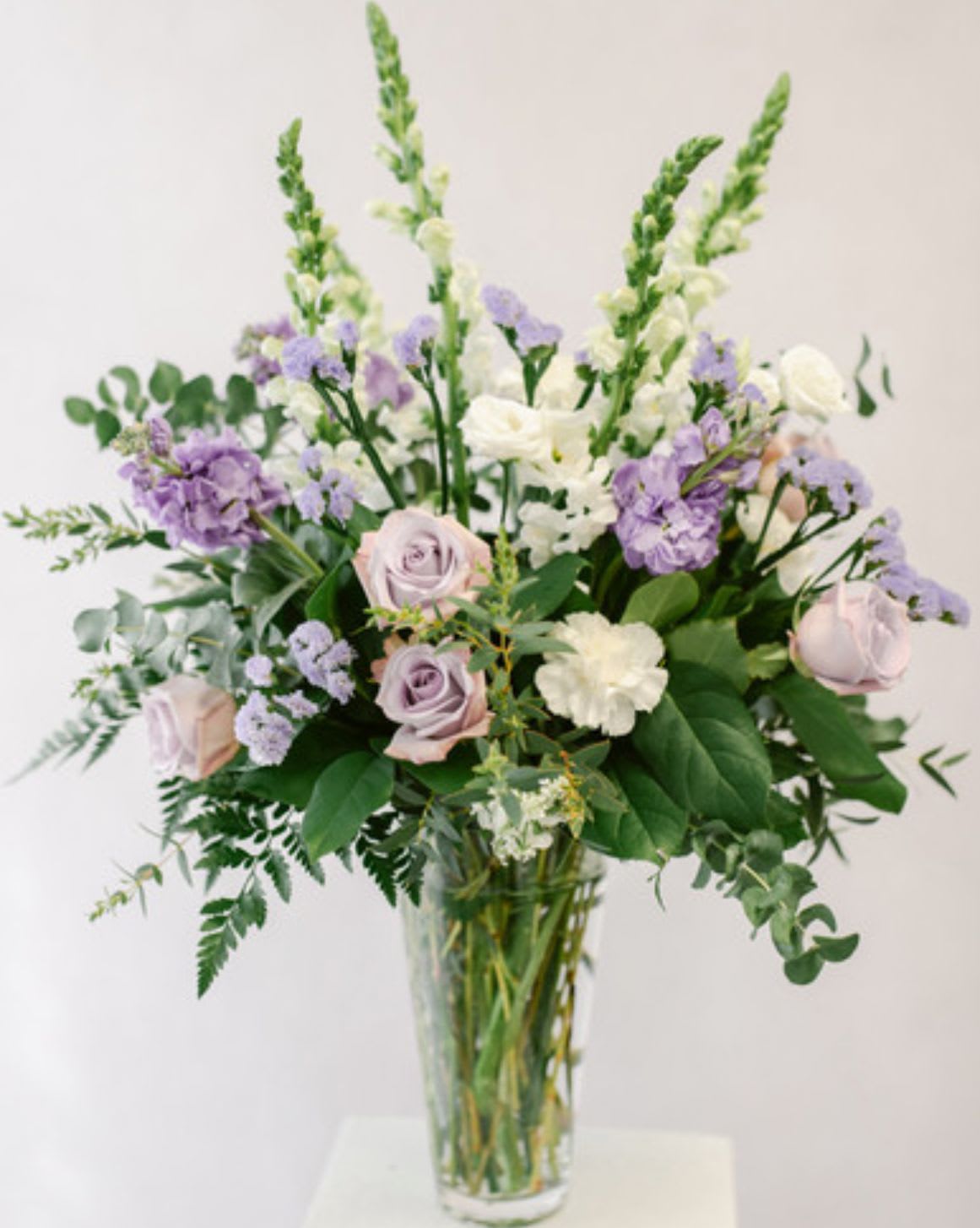 Front Porch Lavender - Soft, peaceful, and full of country charm, Front Porch Lavender captures the feeling of a quiet evening on the porch with a gentle breeze in the air. This elegant arrangement features a soothing blend of lavender and white blooms accented with fresh greenery, creating a light and graceful garden style design. Perfect for celebrating special moments, sending comfort, or simply brightening someone’s day, this bouquet brings a touch of relaxed Southern beauty to any space.