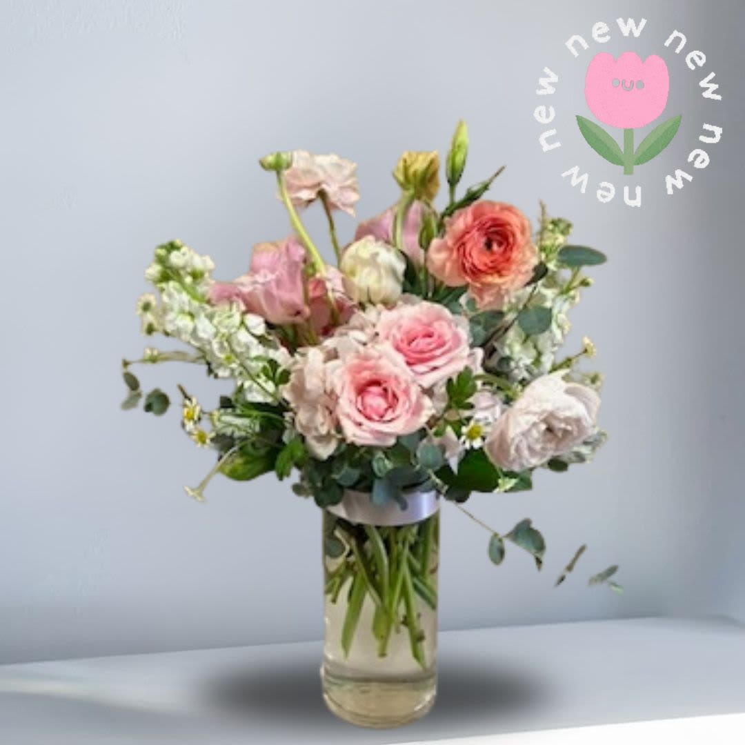 Spring Soirée - Recipe: Seasonal Ranunculus, Spray Roses, Stock, Hydrangae, Lisnathus, Camomille, and Eucalyptus in a clear 7.5" h x 3.5" w vase. Perfect for centerpieces, bar tops, and any spring event.  