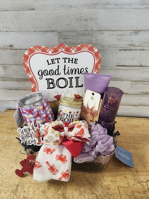 Let the Good Times Boil - $190 - Is there anything that makes Louisiana folks happier than crawfish? Perhaps a crawfish themed gift basket?  Basket Contains: - Swig - Insulated Wine Tumbler - "The Boil" Candle by Bourbon Royalty - Crawfish Earrings with rhinestones - Crawfish Keychain with rhinestones - Crawfish Boil Hair Bow - Let the Good Times Boil Sign - "Spicy, Feisty, &amp; Pricey" - Waterproof Sticker - Crawfish &amp; Crabs Socks - Madame Mystique Fragrance Mist  - Madame Mystique Body Cream - Lavender Loofa - Decorative Acrylic &amp; Gold Tray