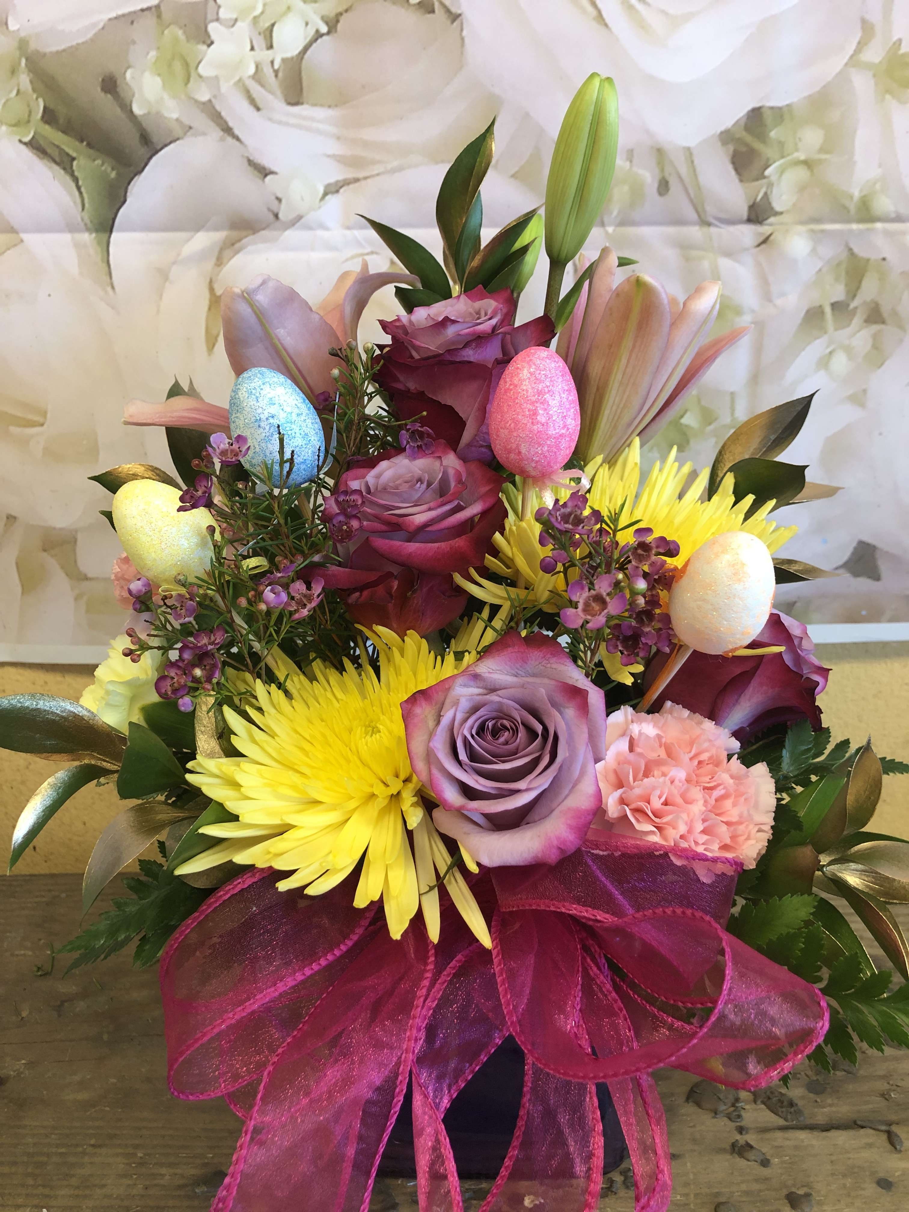 Easter Cube (Designer Choice) - A mixture of flowers to include lily, carnations, roses, spiders, and gold ruscus.  we will add platic eggs on a stick to give it a unique touch.   