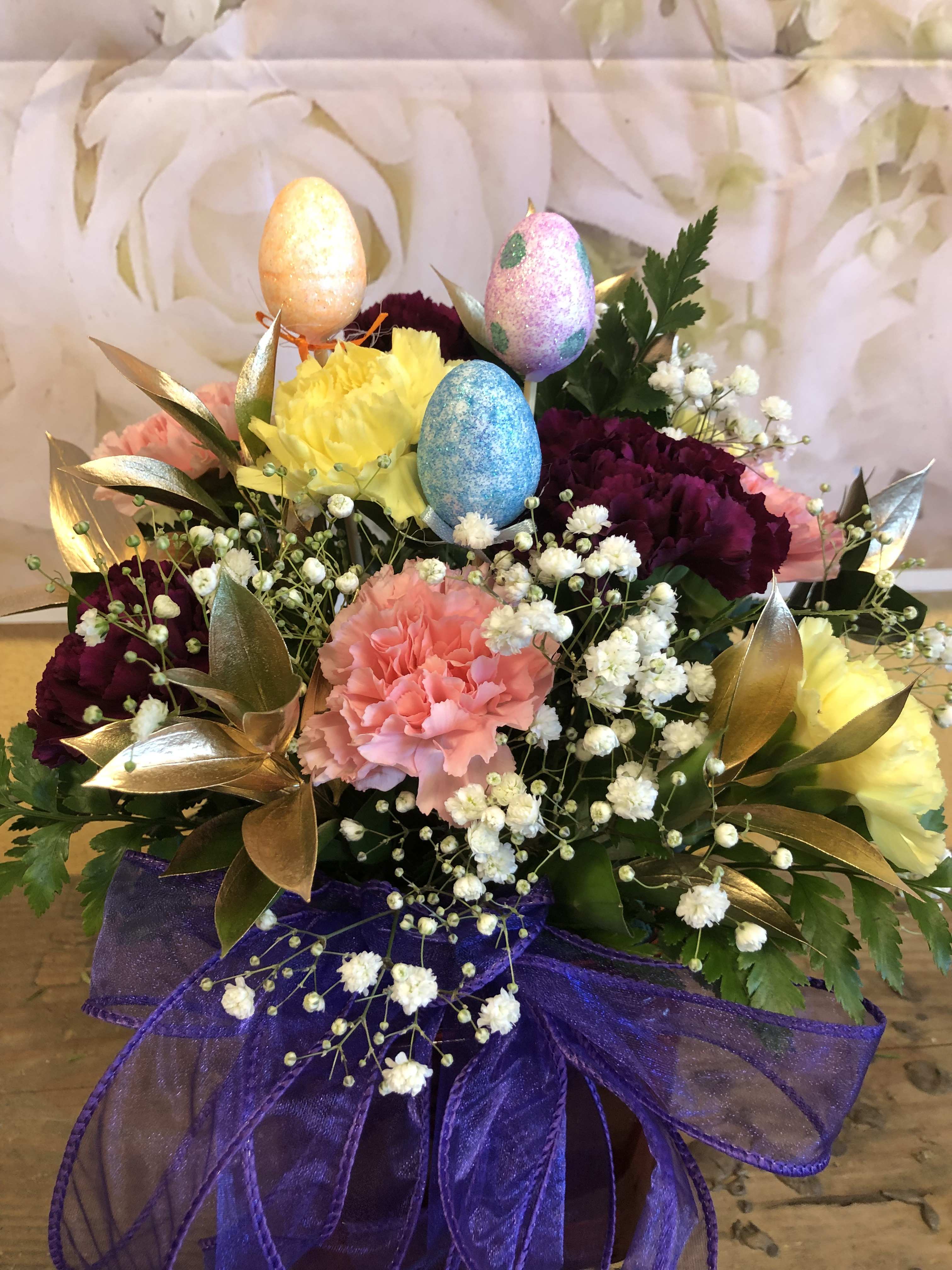 Easter Carnation Cube - Cube with a mixture of colorful carnations we also include baby breath and gold ruscus.  We incorporate plastic eggs on a stick  Standard Price includes 9 carnations Deluxe Price includes 12 carnations Premium Price includes 15 carnations