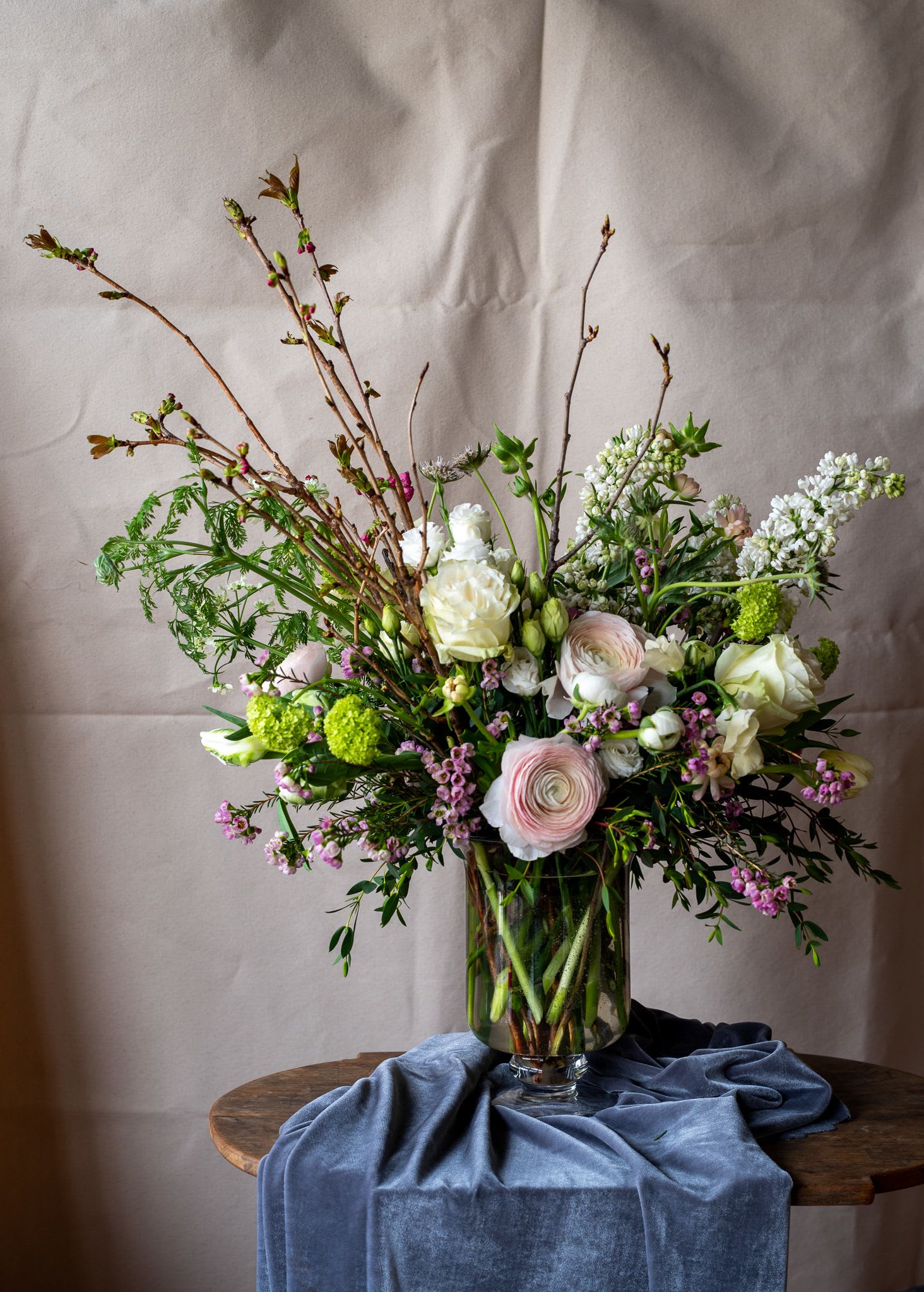 Spring! - Beautiful spring flowering branches, including cherry blossom, viburnum and lilac enhance this quintessential spring bouquet with premium ranunculus, peonies and other seasonal spring flowers.  Perfect for a foyer, kitchen island or anywhere they may be enjoyed.  