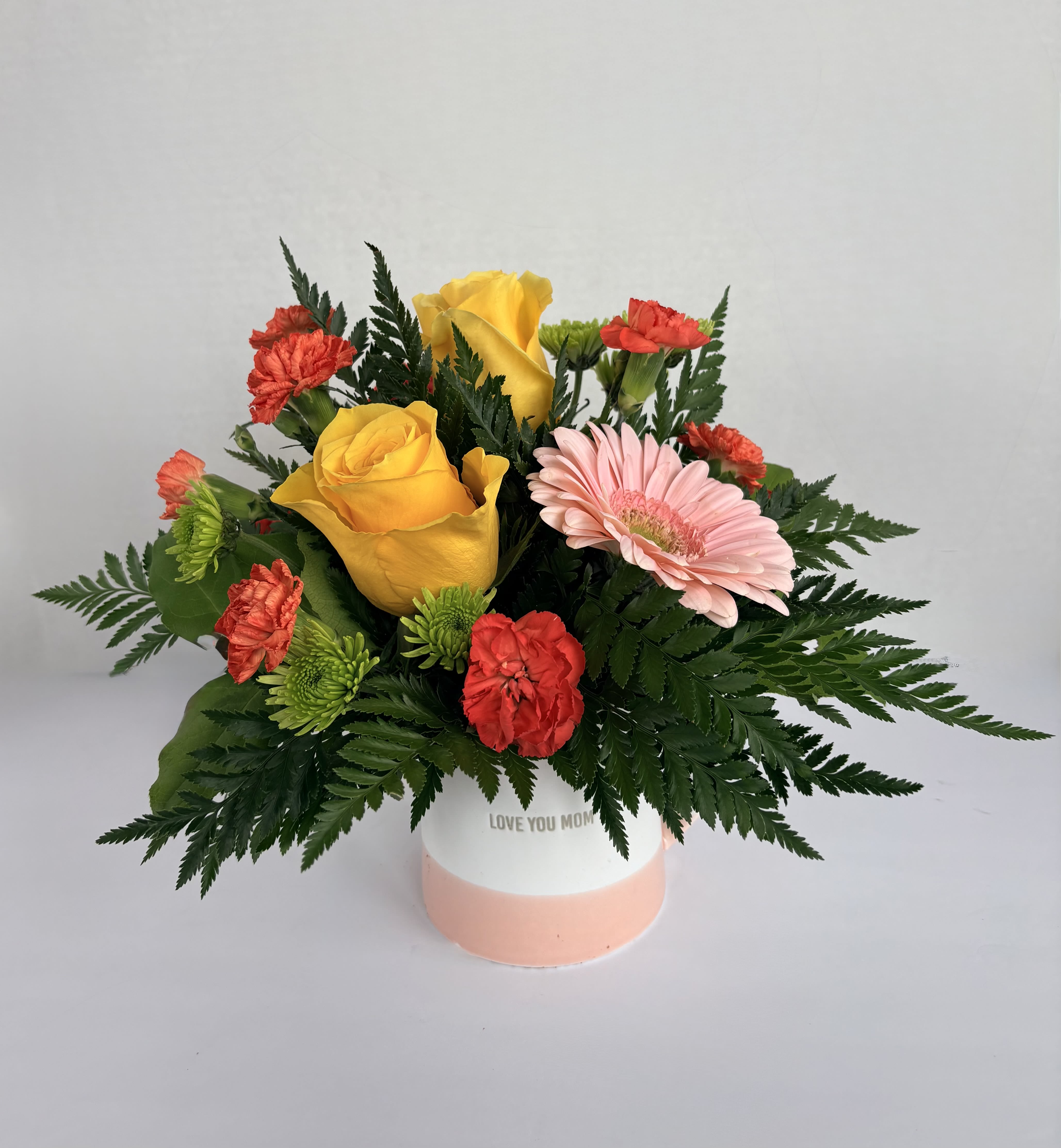 Love You, Mom! - Love You, Mom! Designed in a simple mug with yellow roses, pink gerbera daisy, orange mini carnations, and green daisies is the perfect little gift for any mother figure. Let mom know she's appreciated with the gift of flowers! 