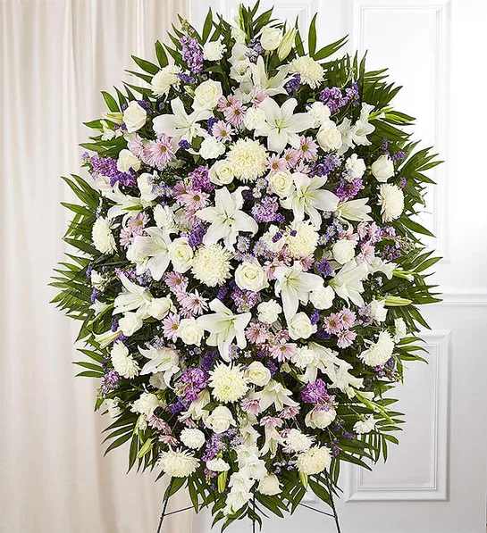 Lavender And White Funeral Standing Spray - When words alone cannot convey the feelings in your heart, flowers can provide a meaningful and profound statement. Our impressive standing spray arrangement is meticulously handcrafted by expert local florists with soothing lavender and white blooms for a lush, full presentation, presenting an elegant and memorable tribute. 