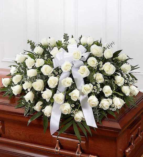 White Rose Half Casket Cover - Half casket cover arrangement of white roses, monte casino and fresh greenery; accented with a white satin ribbon Arrangement measures approximately 16"H x 42"L x 28"D Traditionally sent by the immediate family to the funeral home Our florists use only the freshest flowers available, so colors and varieties may vary