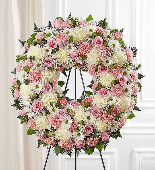 Serene Blessings™ Standing Wreath- Pink &amp; White - Standing wreath arrangement with pink roses, carnations and limonium; white football mums and daisy poms; accented with baby’s breath and soft, lush greenery Large arrangement measures approximately 68"H x 30"L with easel (22 Inch) Small arrangement measures approximately 48"H x 22"L with easel (18 Inch) Appropriate for the funeral home Easel may not be available in all areas Our florists hand-design each arrangement, so colors and assortment may vary based on local availability