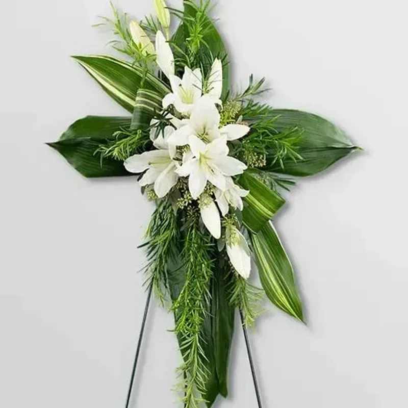 Final Farewell Cross - A gorgeous upright standing floral cross adorned with stunning white lilies and greens to create a serene and graceful tribute