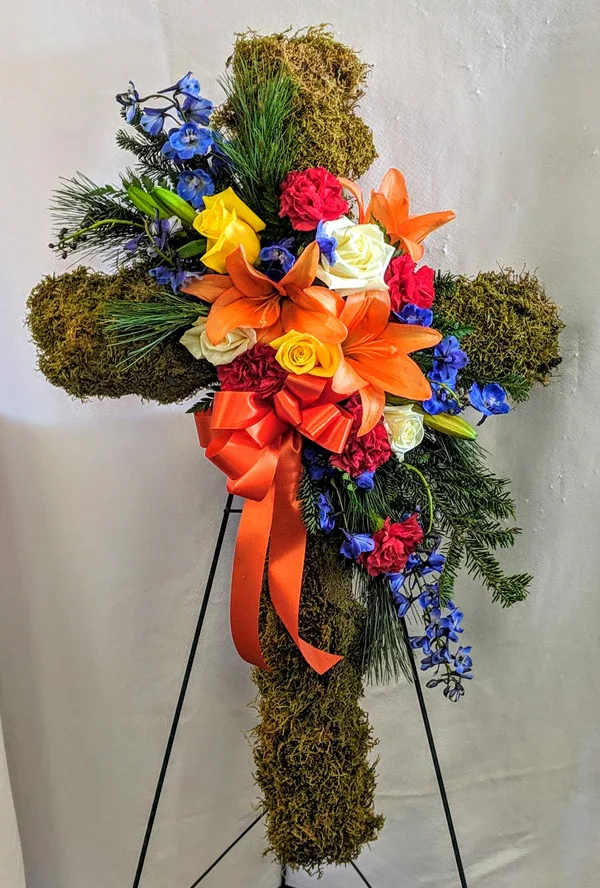 Nature Walk Cross  - A beautifully natural upright standing moss cross accented with thoughtfully arranged colorful lilies roses carnations and delphinium