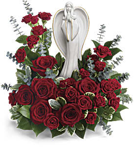 Red rose arrangement with eucalyptus surrounding a white ceramic angel figurine