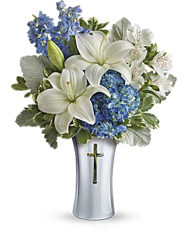 Skies of Remembrance Bouquet  - An elegant expression of your deepest condolences, this majestic mix of blue hydrangea and white lilies will refresh and rejuvenate their spirits. It's hand-delivered in a shining, silver-finished ceramic vase with cross cut-out - a serene, spiritual keepsake they'll always treasure. This majestic bouquet includes blue hydrangea, white asiatic lilies, white alstroemeria, light blue delphinium, dusty miller and variegated pittosporum. Delivered in a Shining Cross vase.