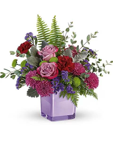 Purple Serenity Bouquet  - A serene style statement in lush lavender roses and fresh maroon blooms, this rich bouquet in an amethyst-colored cube is a beautiful surprise for any occasion! Lavender roses, maroon carnations, purple cushion spray chrysanthemums, green button spray chrysanthemums, and purple sinuata statice are accented with sword fern, leatherleaf fern, dusty miller, and parvifolia eucalyptus. Delivered in Amethyst Color Splash Cube. **KEEPSAKE VASE / SMALL ARRANGEMENT**