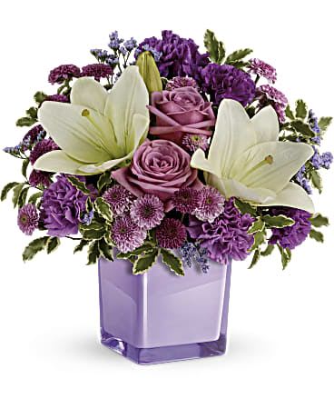 Pleasing Purple Bouquet  - Eager to please! This luxurious bouquet of lavender roses and snow white lilies is a fabulously fragrant way to tickle their fancy. It's lovingly hand-delivered in our exclusive Color Splash cube for a gift that will keep on giving, year after year! Lavender roses, white asiatic lilies, purple carnations, lavender carnations, purple button spray chrysanthemums and lavender button spray chrysanthemums are arranged with lavender limonium and pitta negra. Delivered in a Color Splash cube. *KEEPSAKE VASE / SMALL ARRANGEMENT*