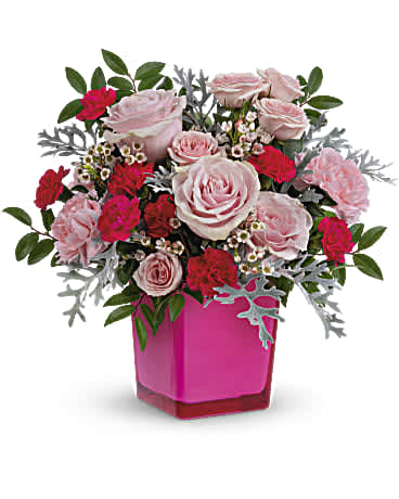 Pink Empowerment  - Pink power! Pretty up any occasion with this fabulously feminine bouquet of pink roses in a hot pink glass cube that lives on as the perfect votive candleholder. This pretty arrangement features pink roses, pink spray roses, miniature hot pink carnations, white waxflower, silver lace dusty miller and huckleberry. Delivered in a Color Splash Cube. *Arrangement is a small to medium size* 