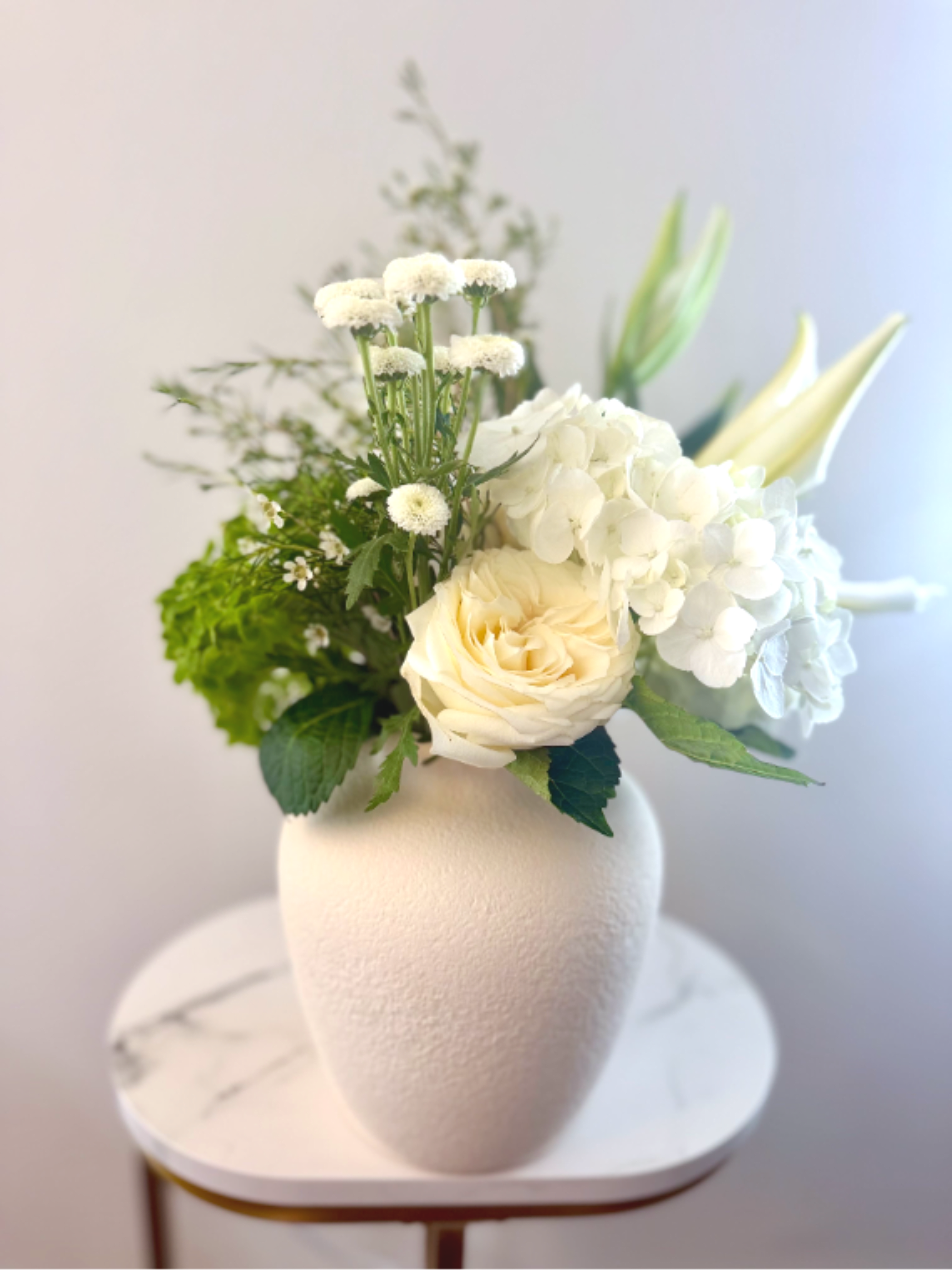 Luxe White Garden - Flower Delivery in Myrtle Beach. A luxury white and green flower arrangement with hydrangeas, roses, and fresh seasonal blooms. Arranged in a sleek matte white ceramic vase for a clean, modern, and timeless look — perfect for elegant gifts, home styling, or special moments.  Same-day delivery in Myrtle Beach available. 