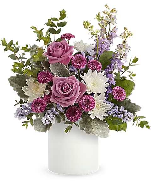 Teleflora's Playfully Yours Bouquet - Gathered in a fun, frosted glass jar, this playful purple bouquet adds feminine charm to any day! Lavender roses, purple button spray chrysanthemums, white cushion spray chrysanthemums, lavender larkspur and lavender sinuata statice are arranged with dusty miller, parvifolia eucalyptus and lemon leaf. Delivered in a Savannah Jar.