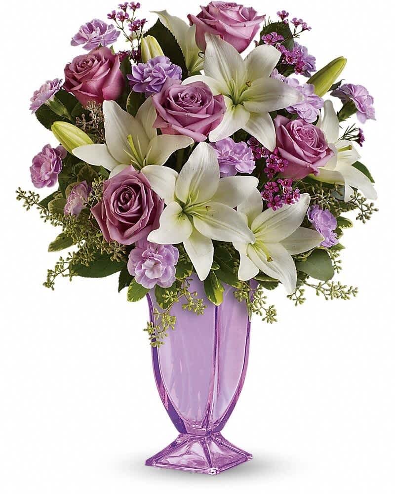 Tall arrangement of white lilies and lavender roses in a lavender glass vase