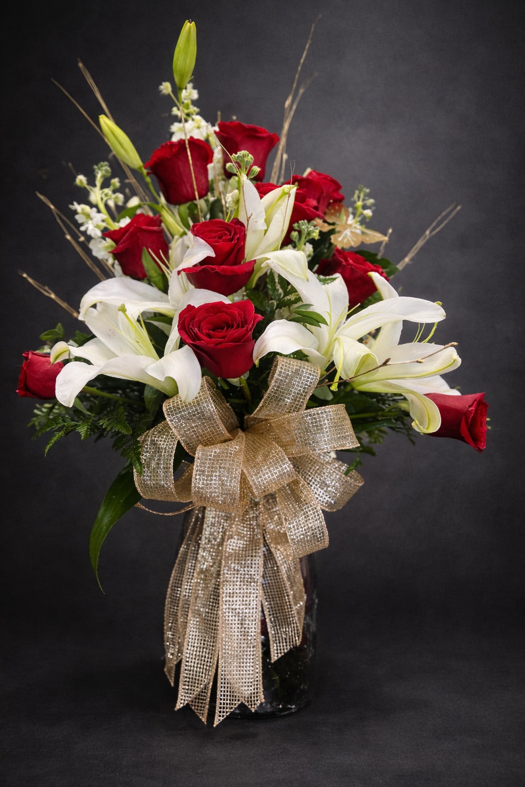 Golden Years - A beautiful one sided red rose arrangement with white cala lilies, greenery and gold accents. 