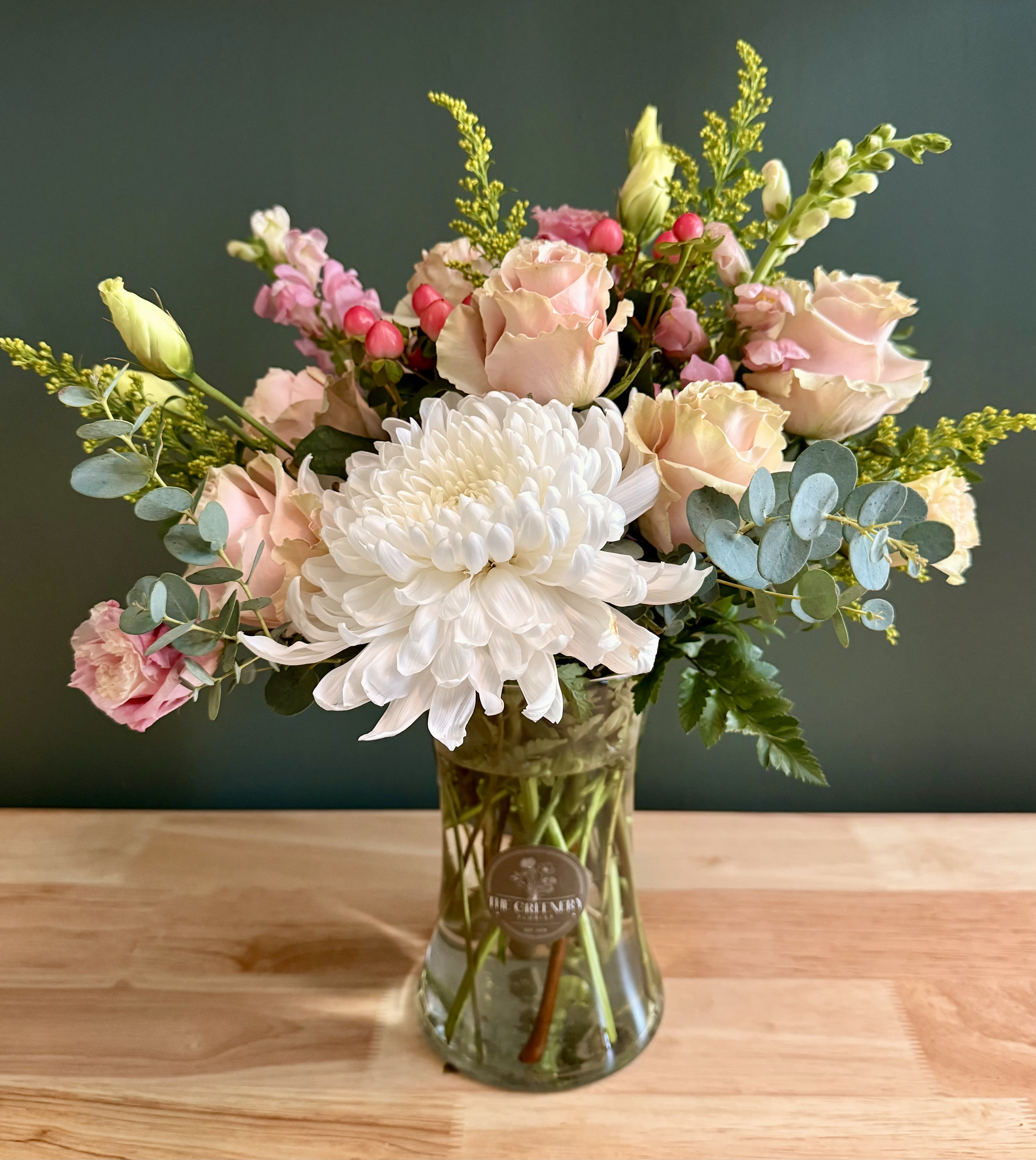 Charleston Charm - A soft, sophisticated floral design for moments that deserve a touch of elegance. Featuring: - Ecuadorian Roses - White Cremone - Solidago - Delicate Lisianthus or Ranunculus - Hypericum - Styled with premium seasonal foliage Presentation Options: Tall clear vase measures approximately 8"9" in H. Every order includes: A custom message card - simply enter your message at checkout and we'll take care of the rest. As a local florist in Charleston South Carolina, everything is made fresh by us here at our flower shop Downtown Charleston.  Please note: Flowers are subject to seasonal availability. If a listed flower is unavailable, our designers will substitute it with flowers of a similar shape, color, and style to maintain the overall aesthetic.