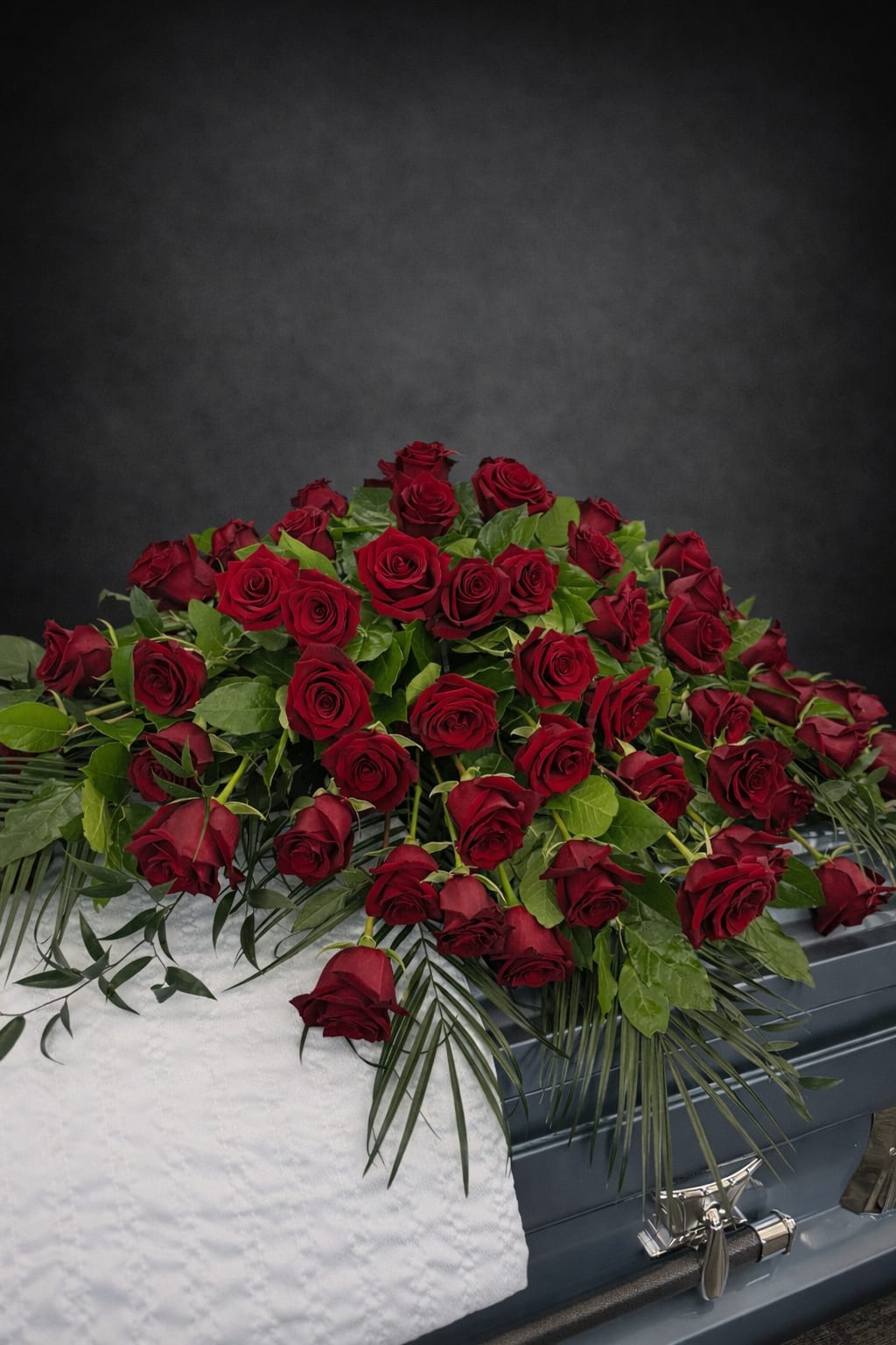 Casket Piece Red Roses - A beautiful casket piece filled with red roses filled with greenery.