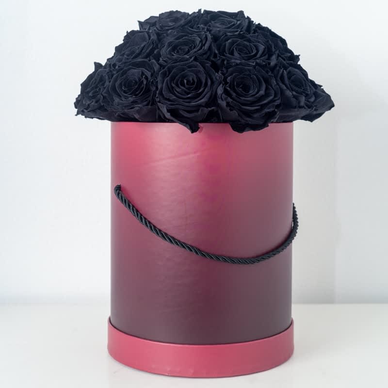 Tall pink hatbox filled with a dome of black roses