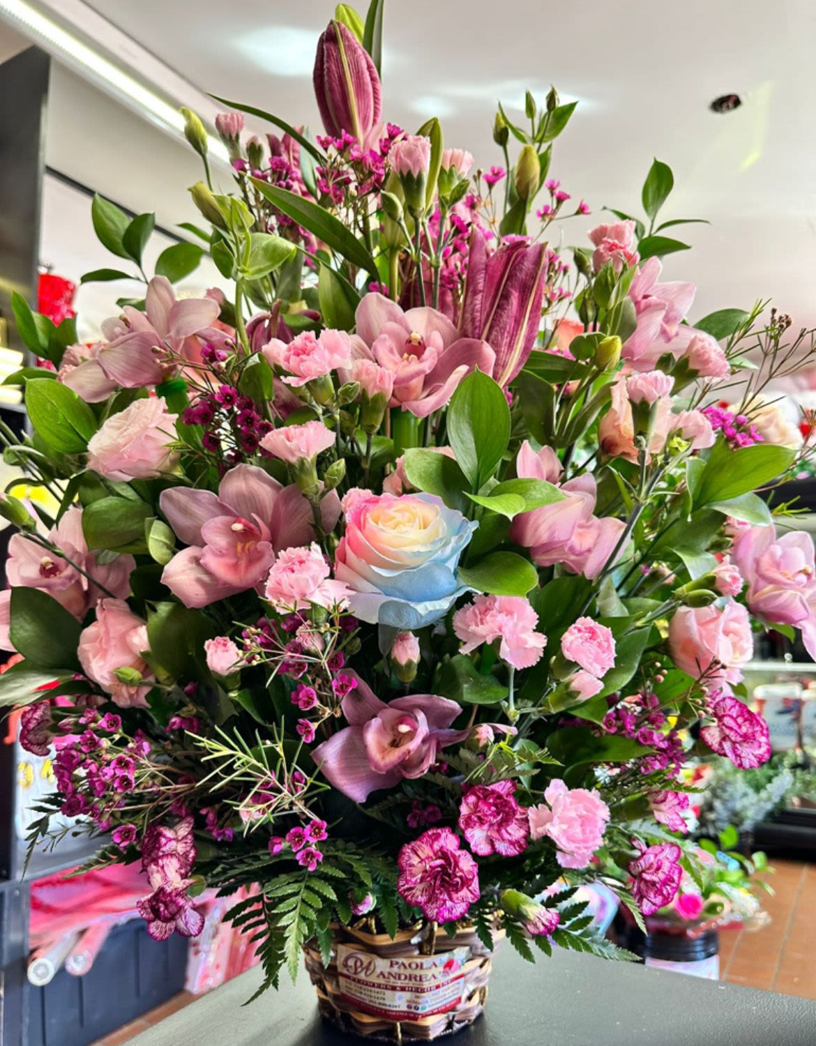 Mix Lily &amp; Mini Carnation Unique Basket Arrangement - A beautiful large mix of lily's and mini carnations filled with greenery and color for any funeral arrangement or a welcome gift