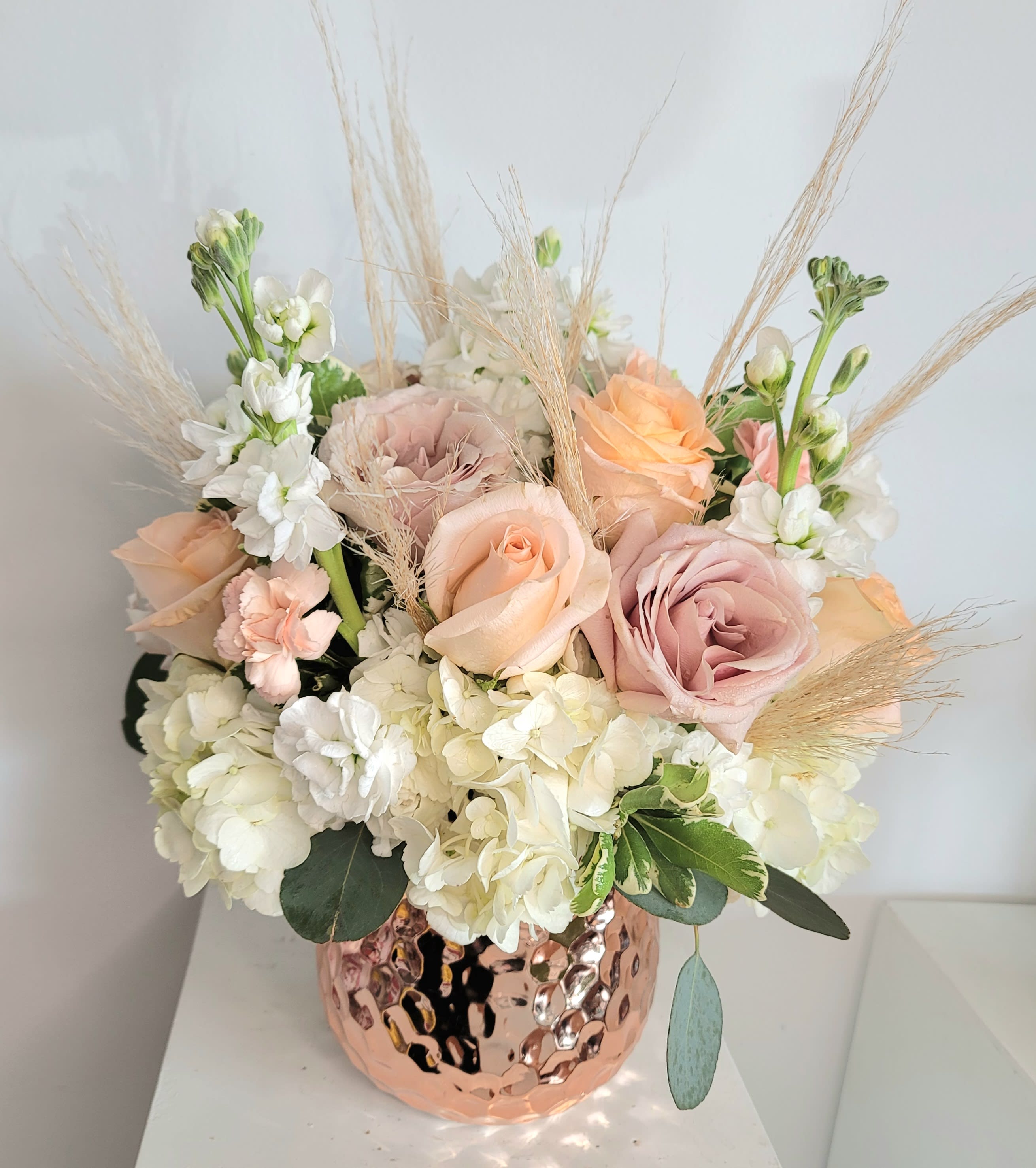 Mother Of Pearl Bouquet - Rose gold square vase with blush pink or peach and white rose mix, white hydrangea and stock flower plus pampas grass with just a touch of silver dollar to make this soft bouquet shine. 