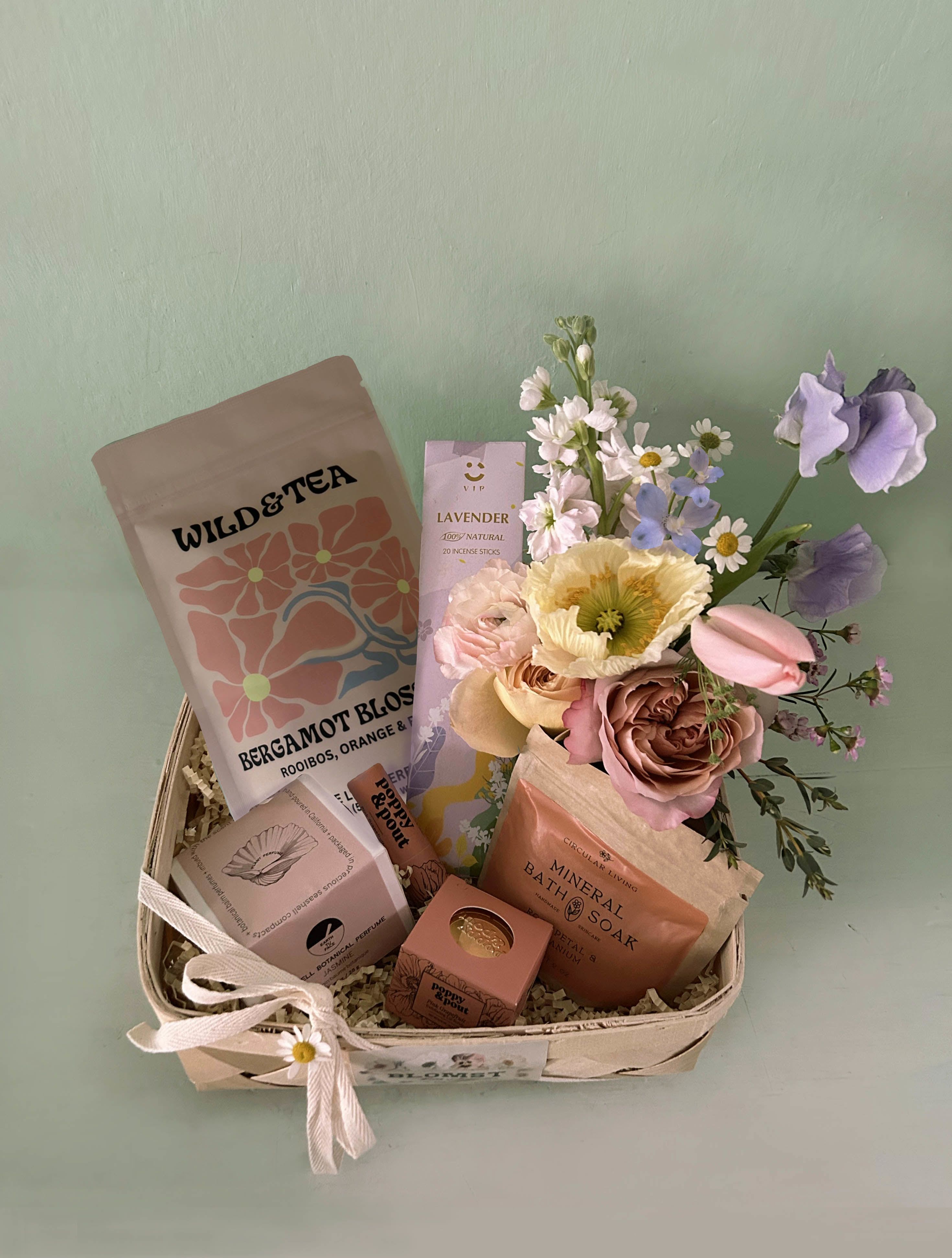 Sienna Spa Box - Lots of heavenly healing goodness in beautiful desert colors in this sweet luxurious care box. Organic and sustainable beauty and wellness products, tea and flowers - to offer a soothing, healing energy for the recipient.  Earth Tu Face pure botanical balm perfume in a real sea shell: Organic cold-pressed safflower, beeswax, and sunflower-derived vitamin E make up the base of this solid perfume. Real Jasmine blossoms, oils of Jasmine.. Circular Living Rose petal and Geranium bath soak: A luxurious mineral soak for sore muscles with rose, geranium, and lemon to balance the skin and cleanse the mind and body. Wild &amp; Tea Bergamot Blossoms Herbal Tea. Organic Ingredients- Red rooibos, chamomile, orange peel, rosehips, cornflower, rose and bergamot oil. 100% Compostable BPA &amp; GMO-Free Packaging Poppy and Pout Pink Grapefruit lip balm: Natural lip balm formula is as smooth as can be. Each cardboard tube is filled from the bottom to the top with lip hydrating goodness. Poppy and Pout Pink Grapefruit lip scrub: Exfoliating Lip Scrub will exfoliate dead skin and leave your lips feeling soft and smooth! LAvender irganic incense sticks in beautiful packaging. Mini Blomst arrangement of fresh, natural stems in a small cylinder vase. All placed in a wooden square box or wooden basket (10 by 10 by 4). Ready for hand delivery in LA. For shippable gift boxes: www.blomstlosangeles.com   