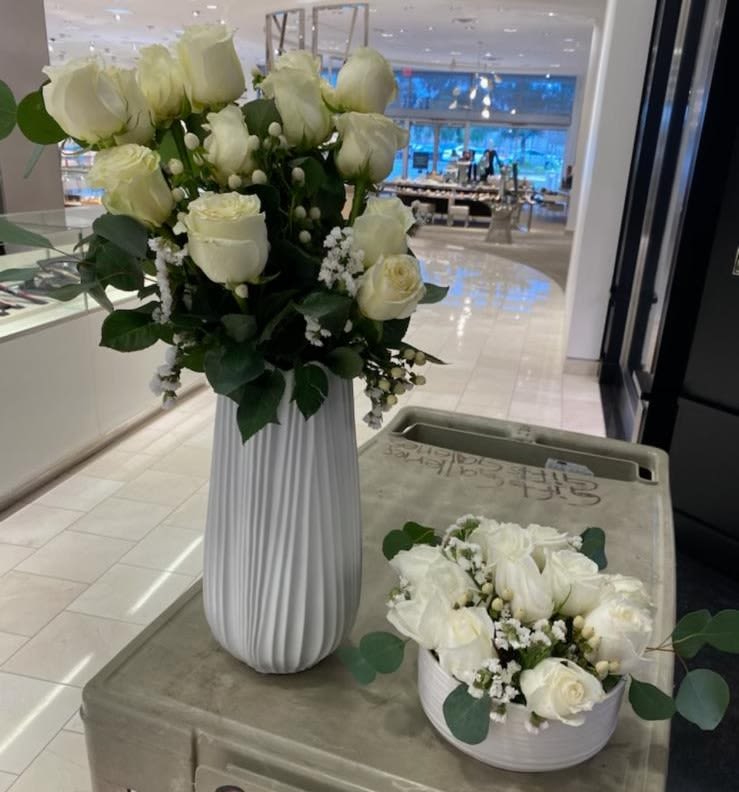 Pristine White Roses Combo - Beautifully curated floral set designed to bring timeless elegance to any space. This arrangement features two vases—one low and one high—creating a stunning layered display. Each vase is carefully filled with pristine white roses, symbolizing purity, love, and remembrance, complemented by lush fresh greens for a natural, sophisticated touch.  Ideal for home décor, special occasions, or heartfelt sympathy gestures.