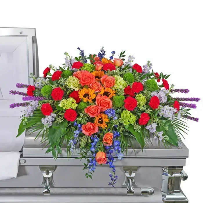 Treasured Memories Casket Spray - Sympathy flowers are a meaningful way to celebrate the life of the deceased, and forever treasure the memories you made together. Our Treasured Memories Casket Spray features Free Spirit roses, sunflowers, bright pink carnations, liatris, stock, green hydrangea, solidago, and premium foliage. Funeral flowers bring healing in many ways, they serve as a memorial to honor the one that we lost, all while providing comfort to the friends and family left behind.