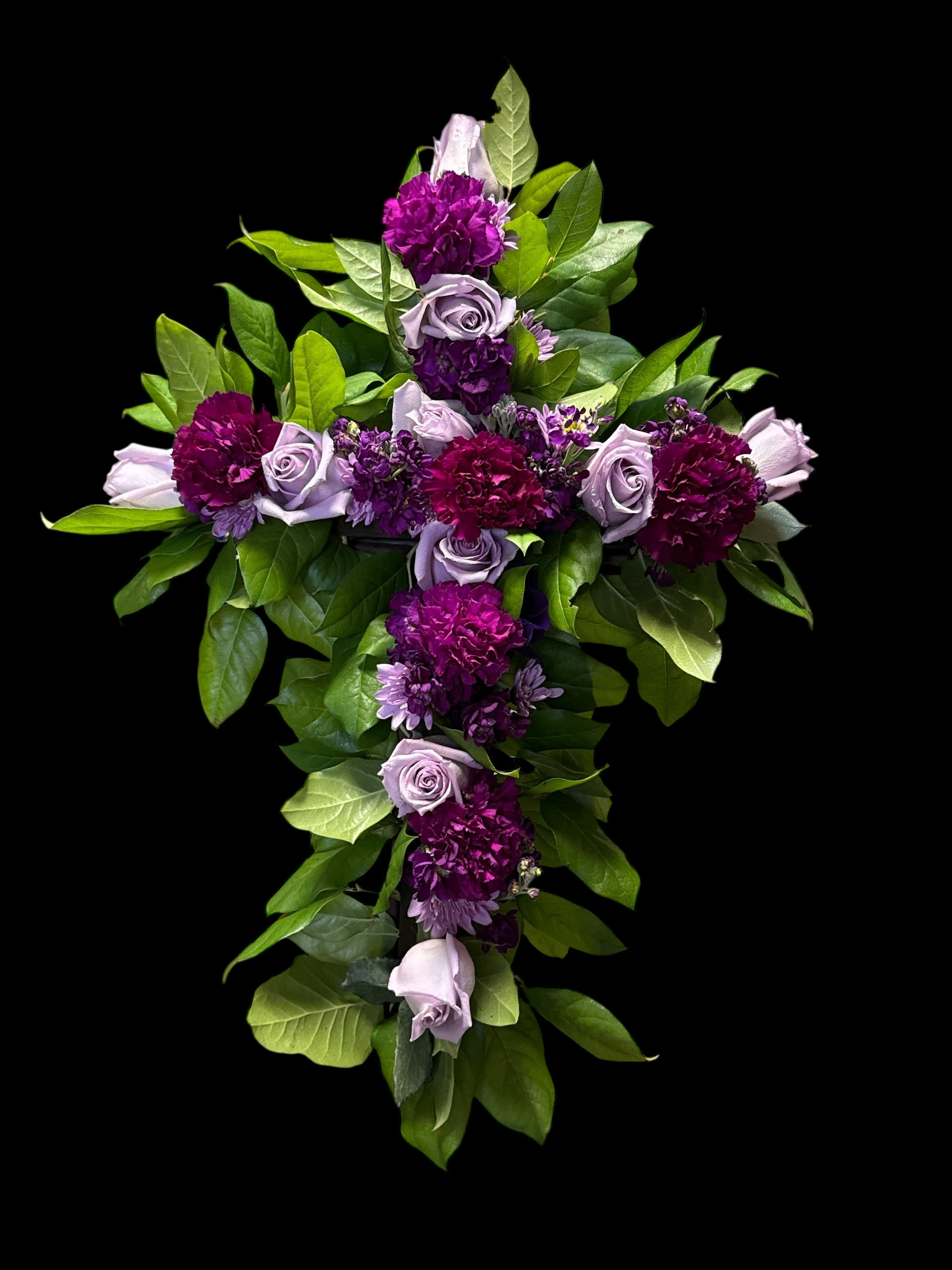 Purple Cross 24" - The Purple Cross Bouquet is a stunning floral arrangement designed to convey heartfelt sentiments with elegance and grace. Featuring a beautifully crafted cross shape adorned with lush, fresh blooms in rich shades of purple, lavender, and complementary accents, this bouquet serves as a meaningful expression of love, remembrance, and peace.  Perfect for memorial services, religious ceremonies, or as a thoughtful gift, the Purple Cross Bouquet blends the serenity of purple tones with the timeless symbolism of the cross. Each arrangement is carefully handcrafted by skilled florists, ensuring both beauty and quality in every detail.