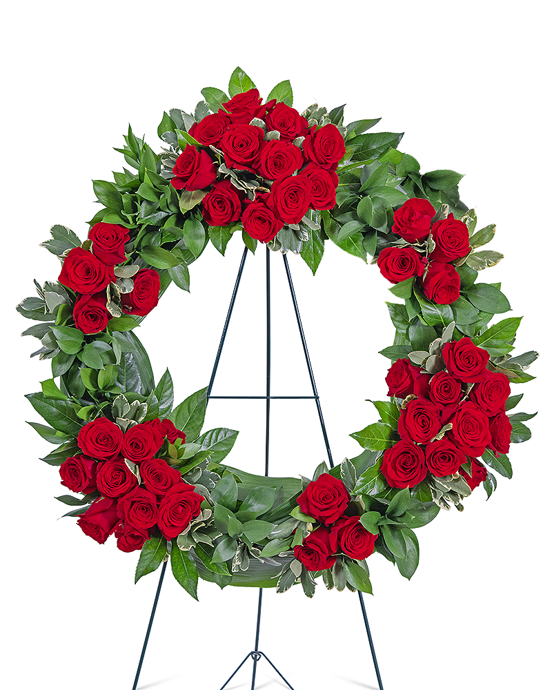 Serene Sanctuary Wreath - The Serene Sanctuary Wreath features roses, Aralia Fatsia, Aspidistra, Ruscus, and other premium foliage. Roses are a beautiful choice for a Funeral or Celebration of Life Service. Whether sent from family, co-workers, or friends, a standing spray or wreath is an appropriate gift of condolence. The circular shape of a wreath in a funeral symbolizes eternal life and is a beautiful way to send your sympathy. Red roses symbolize respect, love, and courage in a sympathy design, which makes these funeral flowers the perfect accent to a funeral or celebration of life ceremony.