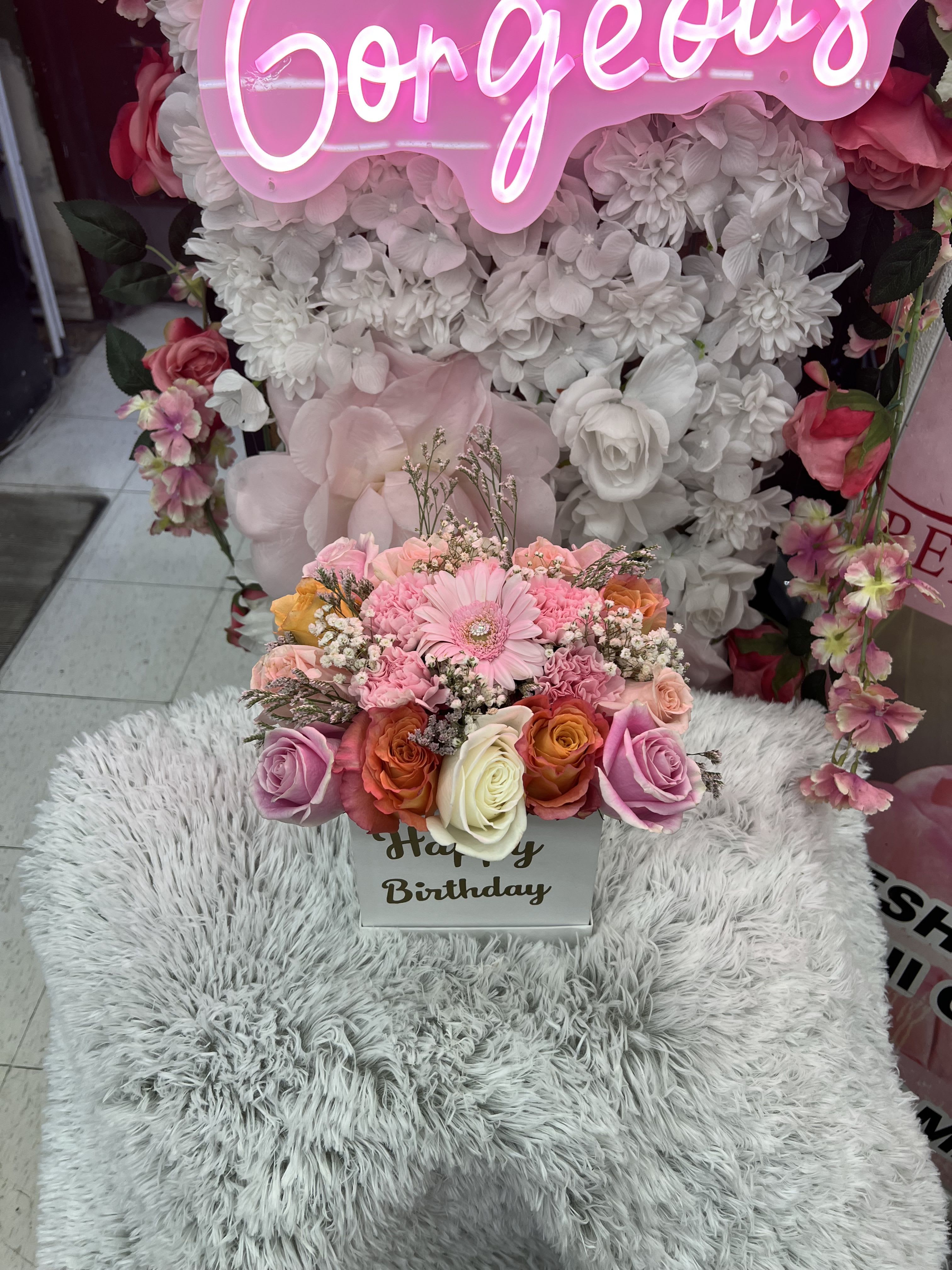 Compact pink and peach rose and gerbera arrangement in a white Happy Birthday box.