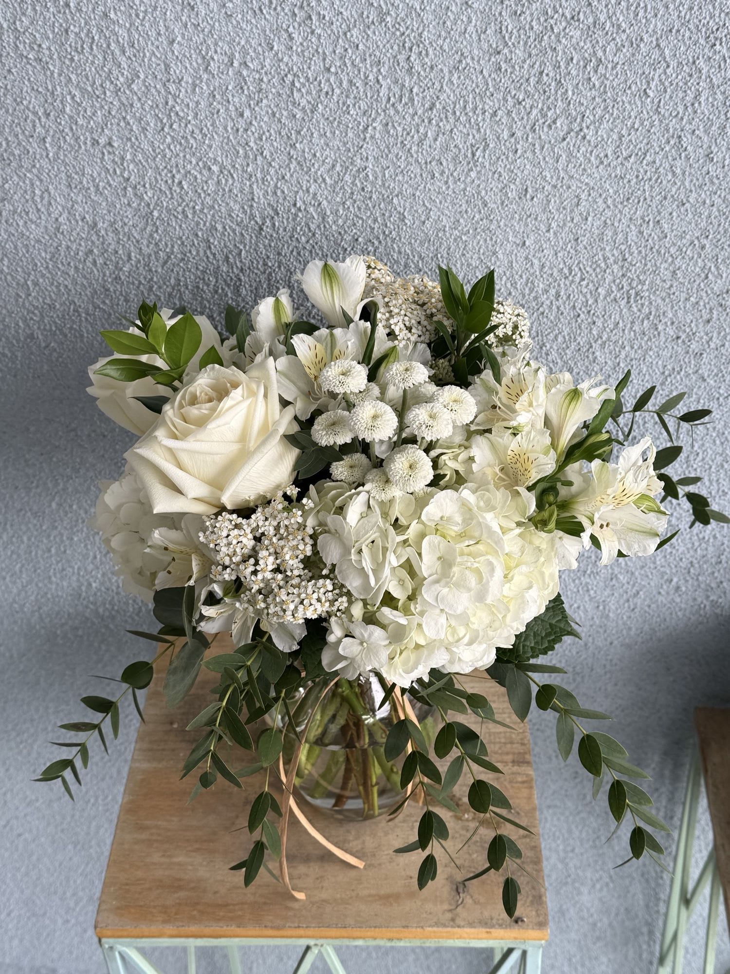 Simply White - All white arrangement filled with hydrangeas, roses, alstroemeria, yarrow and mums with eucalyptus. 